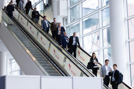 机场核心计划会议与会者乘坐自动扶梯的照片.
